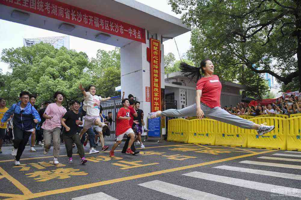 7月8日，高考結束，長沙市第一中學高考考生羅子欣（右）沖出考點大門后以“一字馬”姿態(tài)躍起。她和小伙伴們早就約好，要以一個特殊的方式紀念高中生活結束。新華社發(fā)（辜鵬博 攝）