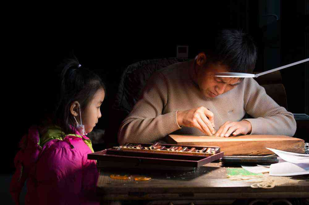 1月7日，在陜西西安明清皮影藝術(shù)博物館，一名前來參觀的小女孩被王可現(xiàn)場制作皮影吸引，駐足觀看。