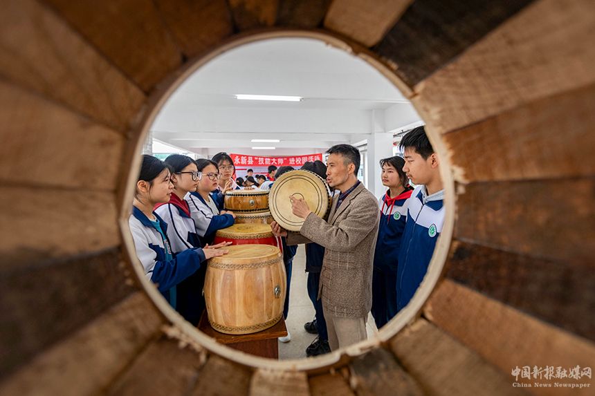 近日，江西省吉安市永新縣開(kāi)展技能大師進(jìn)校園活動(dòng)。當(dāng)?shù)刂乒募寄艽髱熢诮o孩子們傳授制鼓技藝。王惠民攝